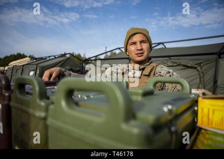 Lance Cpl. Juan Rivera, ein messman mit Sitz Batterie, 14 Marine Regiment, 4 Marine Division überwacht die Verteilung der Chow zu Marines zur Unterstützung der Übung Dynamische Front 19 an Adazi Training Area, Lettland, Jan. 27, 2019. Rund 3.200 Teilnehmer aus 27 Nationen werden an der live-fire Teil der Übung Dynamische Front 19, March 2-9, 2019, in der US-Armee Grafenwöhr Training Area, in Deutschland sowie in Riga, Lettland; und Torun, Polen. Stockfoto