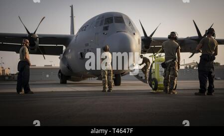 Us-Flieger auf der 75th Expeditionary Airlift Squadron (75 EAS) stehen vor einem C-130J Hercules im Camp Lemonnier, Dschibuti, März zugeordnet. 1, 2019. 75 EAS unterstützt Combined Joint Task Force - Horn von Afrika (CJTF-HOA) mit medizinischen Evakuierungen, Katastrophenhilfe, humanitäre und airdrop Operationen. Stockfoto