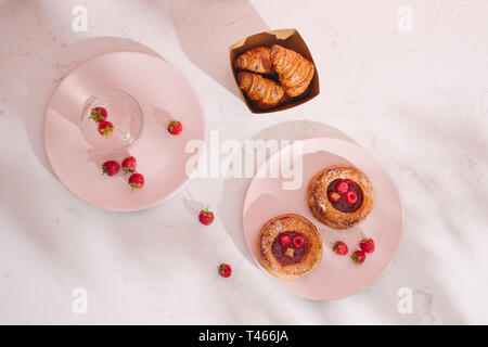 Sweet Summer Dessert hausgemachte gebackene mini Croissants, serviert mit kalten Himbeere Apfelwein, frischen Himbeeren. Auf einem weißen Marmor Tabelle, kopieren Raum oben vie Stockfoto