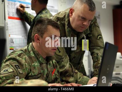 Us-Armee Soldat (rechts), ein Assistent, der Chef der mit der 42th Infantry Division stellt einen Ausbildungsplan mit Master Sgt. Cosmin Codin, ein rumänischer Soldat, der während der übung Dynamische Front 19, am 4. März Grafenwöhr Training Area, Deutschland. Dynamische Vordere 19 ist eine multinationale Übung der US-Armee in Europa zur Verbesserung der Alliierten und Partner nation Fähigkeit zu lange liefern - Bereich Feuer. Es ermöglicht Verbündeten persönlich, fachlich, technisch und taktisch stärker und fähiger Kräfte in der Zeit der Krise zu schaffen. Stockfoto