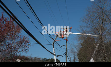 Männer im Eimer auf erweiterten Cherry Picker Instandsetzung der elektrischen Kabel Stockfoto