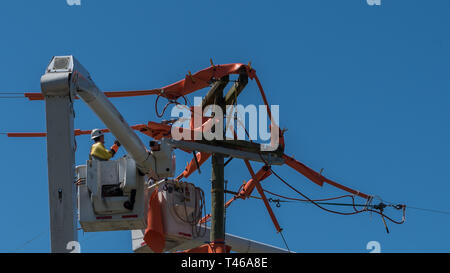 Männer im Eimer auf erweiterten Cherry Picker Instandsetzung der elektrischen Kabel Stockfoto