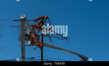 Männer im Eimer auf erweiterten Cherry Picker Instandsetzung der elektrischen Kabel Stockfoto