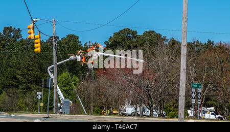 Männer im Eimer auf erweiterten Cherry Picker Instandsetzung der elektrischen Kabel Stockfoto