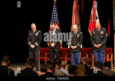 Us-Armee Generalleutnant Thomas S. James jr., Links, Kommandant der 1. Armee, ehemaliger US-Armee Kapitän Andrew L. Bundermann, Mitte, Infanterie Offizier Truppe B zugeordnet sind, 3.Staffel, 61 Cavalry Regiment, 4. Brigade Combat Team, 4 Infanterie Division, U.S. Army Maj Stoney L. Portis, ehemaliger Kommandant der Truppe B, 3.Sqdr., 61. Cav. Reg. und U.S. Army Command Sgt. Maj. Dwayne Koch, Senior Soldaten Führer für 1 U.S. Army, Bug ihre Köpfe während der anrufung, 7. März 2019, während eines Distinguished Service Cross Zeremonie an der Northrop Auditorium in Minneapolis, Minnesota. Die Auszeichnung wurde presen Stockfoto