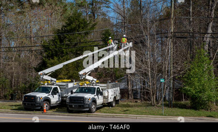 Zwei Arbeiter in einem Cherry Picker schaufel Arbeiten an elektrischen Leitungen Stockfoto