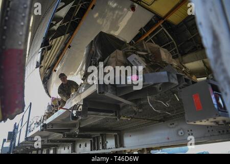 Staff Sgt. Benjamin Griggs, 386 Expeditionary Logistik Bereitschaft Squadron Ramp Services Supervisor, bereitgestellt vom 89. Antenne Anschluss Squadron bei Joint Base Andrews, Md., Brötchen Cargo an einen kommerziellen Iljuschin Il-76 im Ali Al Salem Air Base, Kuwait, 11. März 2019. Die US Air Forces Central Command Air Mobility Division und Luftbrücke Control Team die Nutzung der Commercial international heavyweight Luft Angebote orchestrieren Theater Cargo zu bewegen. Die Verwendung von Ihat Missionen bietet die Luftbrücke USCENTCOM Theater eine wichtige Fähigkeit für Fracht, die nicht auf militärische Luft geplant werden Stockfoto