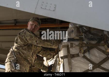 Staff Sgt. Benjamin Griggs, 386 Expeditionary Logistik Bereitschaft Squadron Ramp Services Supervisor, bereitgestellt vom 89. Antenne Anschluss Squadron bei Joint Base Andrews, Md., Brötchen Cargo an einen kommerziellen Iljuschin Il-76 im Ali Al Salem Air Base, Kuwait, 11. März 2019. Die US Air Forces Central Command Air Mobility Division und Luftbrücke Control Team die Nutzung der Commercial international heavyweight Luft Angebote orchestrieren Theater Cargo zu bewegen. Die Verwendung von Ihat Missionen bietet die Luftbrücke USCENTCOM Theater eine wichtige Fähigkeit für Fracht, die nicht auf militärische Luft geplant werden Stockfoto