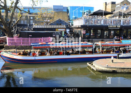 Lastkahn mit Touristen und Camden Lock auf der Regents Canal, im Frühjahr die Sonne, im Norden von London, Großbritannien Stockfoto