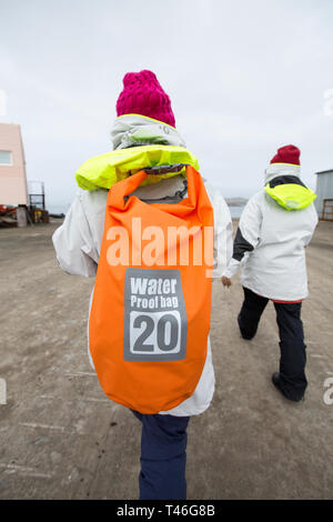 Chinesische Touristen mit einem wasserdichten Beutel nach der Landung am Flughafen Rodolfo Teniente Marsh Martin auf King George Island, für eine polar Cruise. Stockfoto