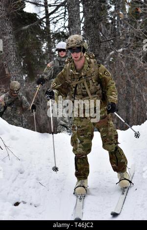 Bei kaltem Wetter Führer Kurs 19-004 Studenten ski entlang Hippie Trail am nördlichen Warfare Training Center Black Rapids Training Website während der 10 Kilometer im Biathlon vom 12. März 2019. Das kalte Wetter Führer Kurs schult Kader- und platoon-Führer in die Kenntnisse und Fähigkeiten, die zur erfolgreichen kleinen unit operations in einer kalten, verschneiten Umgebung durchführen. Schwerpunkt liegt dabei auf den Auswirkungen der Kälte auf Personal und Material, die Nutzung von grundlegenden kaltem Wetter Kleidung und Ausrüstung, winter Bereich Handwerk, Schneeschuh und Ski Techniken und Winter oder kalten Regionen Navigation und Routenplanung Stockfoto