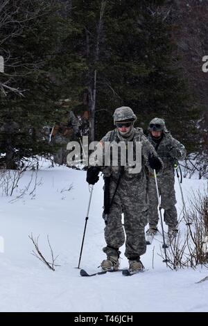 Bei kaltem Wetter Führer Kurs 19-004 Studenten ski entlang Hippie Trail nach dem Feuern Teil des 10 Kilometer langen Biathlon am Schwarzen Rapids Training Website März 12 der Nördlichen Warfare Training Center, 2019. Das kalte Wetter Führer Kurs schult Kader- und platoon-Führer in die Kenntnisse und Fähigkeiten, die zur erfolgreichen kleinen unit operations in einer kalten, verschneiten Umgebung durchführen. Schwerpunkt liegt dabei auf den Auswirkungen der Kälte auf Personal und Material, die Nutzung von grundlegenden kaltem Wetter Kleidung und Ausrüstung, winter Bereich Handwerk, Schneeschuh und Ski Techniken und Winter oder kalten Regionen navigati Stockfoto