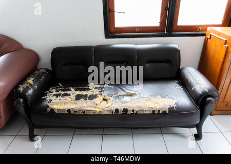 Gebrochen und alten, braunen couch Stühle in das kleine Zimmer mit weißen Boden Stockfoto