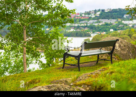 Bank ohne die Menschen in einem malerischen Ort in der Natur. Sitzbank mit Blick auf den Teich in der Nähe des Hauses von Edvard Grieg. Stockfoto