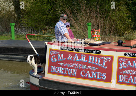 Glücklich oben Foxton locks auf Th Grand Union Canal zu sein - eine bunte Kanal Boot und Besatzung von 2 Personen und Hund lächeln in die Kamera. Stockfoto