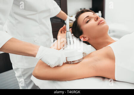 Frau erhält Anti-Cellulite-Massage, Kavitation Verfahren an Hand Stockfoto