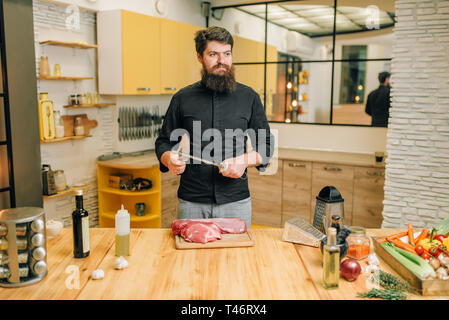 Mann mit Messer bereitet rohes Fleisch zu schneiden Stockfoto