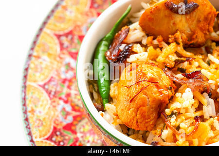 Close up Halal Indischen chicken Biryani serviert mit Joghurt tomato Raita über weißen Hintergrund. Selektive konzentrieren. Stockfoto