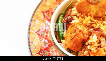 Close up Halal Indischen chicken Biryani mit Safran mit Joghurt tomato Raita auf weißem Hintergrund serviert. Selektive konzentrieren. Banner Stockfoto