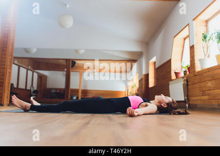 Seitenansicht Porträt der schönen jungen Frau Arbeiten, Ausruhen nach Yoga Übungen, liegen in Savasana, Leiche oder Toten Körperhaltung, entspannend Stockfoto