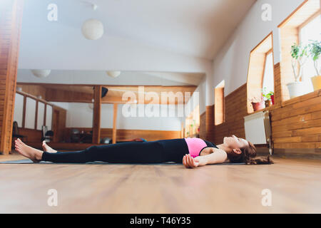 Seitenansicht Porträt der schönen jungen Frau Arbeiten, Ausruhen nach Yoga Übungen, liegen in Savasana, Leiche oder Toten Körperhaltung, entspannend Stockfoto