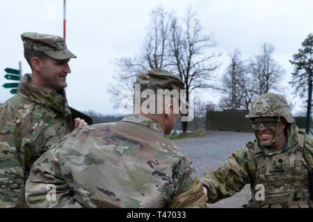 Us-Armee Oberstleutnant Christopher W. Baker, Kommandant der Feuerwehr 173rd Support Bataillons, 173Rd Airborne Brigade, und Command Sgt. Maj. Felicia D. Rodriguez, willkommen Brig. Gen. Christopher C. LaNeve, Kommandierender General der 7. Armee den Befehl, und Oberst James Bartholomees III, Kommandant der 173Rd Airborne Brigade, die im Rahmen eines Besuches der Brigade während der Übung Lipizzaner V bei Pocek in Postonja, Slowenien, März 13, 2019. Lipizzaner ist eine kombinierte Squad-level Training in der Vorbereitung für platoon Bewertung und Bataillon-Bereitstellungsverfahren zu überprüfen. Die 173Rd Stockfoto