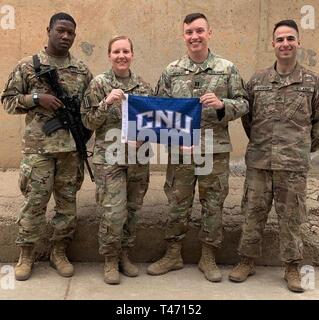 Task Force Cavalier Soldaten, Sgt. Roger Jackson, Staff Sgt. Kaitlyn Ellis, Kapitän Ryan Brownell, und Cpl. David Levenson, alle von der 529th Support Battalion, die alle Absolventen von Christopher Newport University, Newport News, Virginia, nehmen Sie sich einen Moment Zeit, um ein Foto zusammen zu Ehren des cnu Tag 2019, 14. März 2019, Camp Taji, Irak zu erfassen. Stockfoto