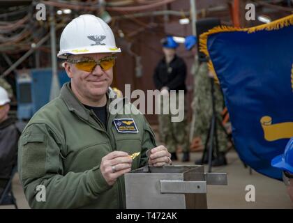 NEWPORT NEWS, Virginia (15. März 2019) Kapitän Daryle Cardone, Executive Officer der Nimitz-Klasse Flugzeugträger USS George Washington (CVN 73), Orte Andenken in eine Time Capsule während der Mast-Stepping Zeremonie auf dem Schiff Flight Deck statt. George Washington wird gerade Tanken komplexe Überholung (RCOH) bei Newport News Werft. RCOH ist ein fast 4-jährigen Projekt nur einmal während einer Fluggesellschaft, die 50-jährige Nutzungsdauer, einschließlich Betankung von zwei nukleare Reaktoren des Schiffes sowie erhebliche Reparaturen, Upgrades und Modernisierung. Stockfoto