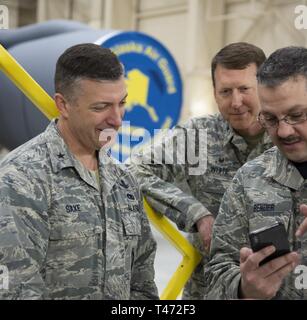 Brig. Gen. Torrence Saxe, der Adjutant General, Alaska National Guard, Uhren ein Video des neuen Maintenance steht mit Senior Master Sgt installiert. George Bender und 168 Wing Commander, Oberst Bryan White, innen Hangar auf eielson Air Force Base, Alaska, 14. März 2019. Vor dem Werden der Adjutant General, Saxe den Innenraum - Alaska Air National Guard Einheit geboten hat, und dieser Besuch war sein erster Besuch als Kommandeur aller Luft- und Army National Guard Personal in Alaska. Stockfoto