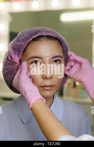 Microbleeding Augenbrauen und Architektur. Kosmetikerin Schaltung erzeugt und Symmetrie Augenbrauen. Schönheitsbehandlungen in Spa Salon Stockfoto