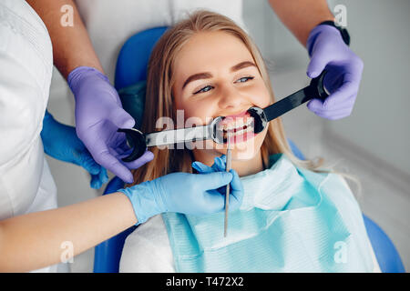 Schöne Mädchen sitzen in der Zahnarztpraxis Stockfoto