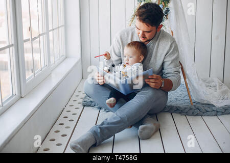 Vater sitzt zu Hause mit kleinen Sohn Stockfoto