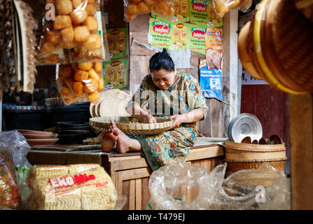 Markthalle mit einem lokalen Frau mit einem Weidenkorb sitzen auf einer Bank, Sortierung Bohnen von Hand. Borobudur Valproto, Java, Indonesien. Stockfoto