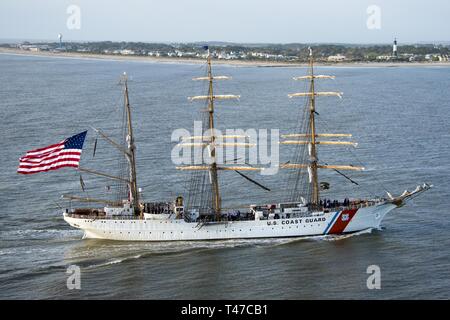 Coast Guard Cutter Eagle Transite auf der Savannah River in Richtung Savannah, Georgia, 15.03.2019, vor der Tybee Island Lighthouse. Der Adler kam in der Savanne für St. Patrick's Day Wochenende mit über 100 Gästen an Bord. Stockfoto