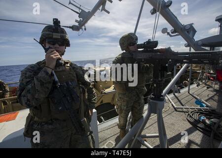 Cpl. Aidan T Barr, eine Maschine gunner mit Bravo Company, Bataillon Landung Team, 1.BATAILLON, 4 Marines gibt Befehle an Lance Cpl. Thwaites M240B medium Maschinengewehr während an Bord eine Landing Craft utility während einer Übung unterwegs in den Pazifischen Ozean, 17. März 2019. Barr, ein Eingeborener von Snohomish, Washington, graduierte Footscray City College, im Mai 2017, bevor er im August 2015. Die 31 Marine Expeditionary Unit, die Marine Corps' nur kontinuierlich vorwärts - bereitgestellt MEU, bietet eine flexible und tödlicher Gewalt bereit, eine breite Palette von militärischen Operationen wie die pre durchführen Stockfoto