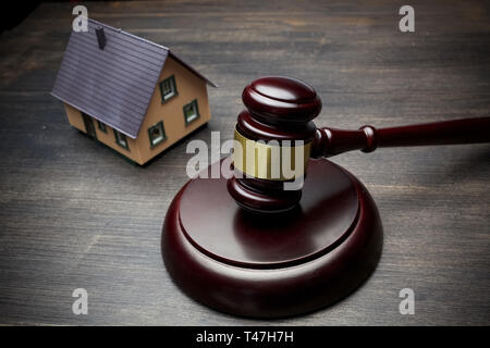 Hammer des Richters, das Haus auf schwarzem Holz Hintergrund. Immobilien. Stockfoto