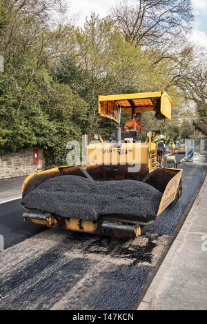 Presteigne, Powys, Wales, UK. Ein fertiger Asphalt oder Pflaster Maschine mit frischem Asphalt auf einer Straße in der Stadt Stockfoto