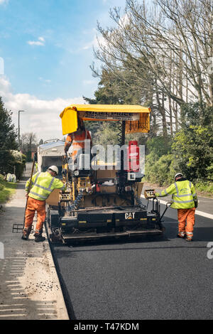 Presteigne, Powys, Wales, UK. Ein fertiger Asphalt oder Pflaster Maschine mit frischem Asphalt auf einer Straße in der Stadt Stockfoto