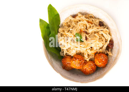 Asiatische Lebensmittel Konzept hausgemachte orientalische Eiernudeln und die würzigen Fleischbällchen in Keramik Schüssel auf weißem Hintergrund Stockfoto
