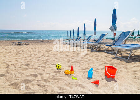 Spielzeug auf Sand gegen das türkisfarbene Meer. Tourismus und Urlaub Konzept an einem tropischen Strand. Happy sonnigen Tag am Strand. Stockfoto