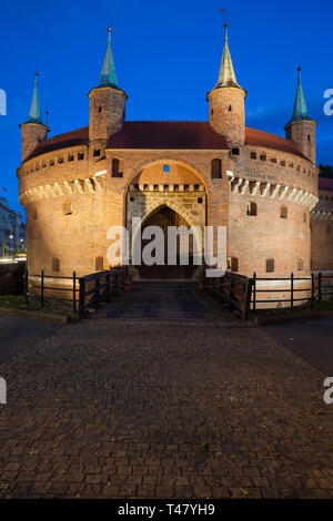 Barbican bei Nacht in der Altstadt von Krakau, Polen, ein Teil der alten Stadtmauer Festung, befestigte Außenposten aus dem 15. Jahrhundert. Stockfoto