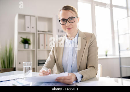 Attraktive Office Specialist bei der Arbeit mit Bericht Stockfoto