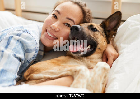Schöne asiatische Frau umarmen Hund Stockfoto