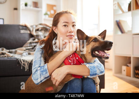 Asiatische Frau posiert mit Hund Stockfoto