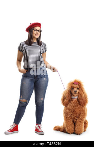 Junge elegante Mädchen mit einem roten Pudel an der Leine auf weißem Hintergrund posiert Stockfoto