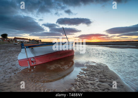 Sonnenuntergang über einem Fischerboot bei Burnham Overy Staithe ein hübsches Fischerdorf an der Küste von Norfolk Stockfoto