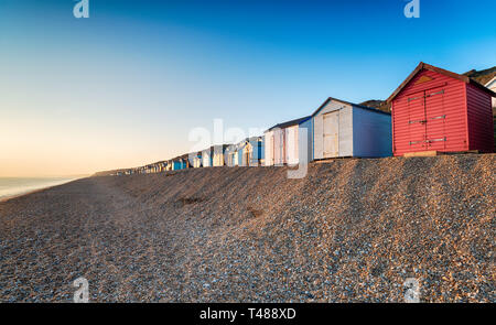 Eine Reihe von bunten Badekabinen am Kiesstrand am Milford on Sea auf der Hampshire Küste Stockfoto