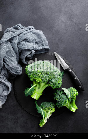 Frische Brokkoliröschen auf schwarzem Hintergrund, Ansicht von oben Stockfoto