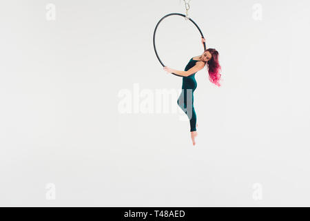 Ein junges Mädchen führt die akrobatische Elemente in der Luft. Studio shooting Leistungen auf einem weißen Hintergrund. Stockfoto