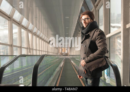 Gut aussehender Mann stand vor der Rolltreppe in der U-Passage. Stockfoto